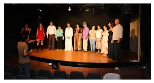 אנשים עומדים במרכז הבמה של לימודי תיאטרון